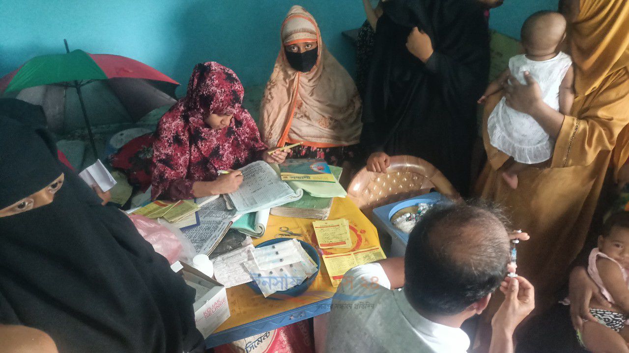শিশুদের টিকা দিতে গিয়ে  ২ঘন্টা সময় ধরে দাঁড়িয়ে থাকার পর টিকা দিতে হচ্ছে বাচ্চাদের।